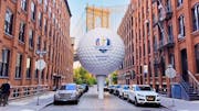 A giant golf ball teed up in the streets of New York, with the Ryder Cup logo on it.