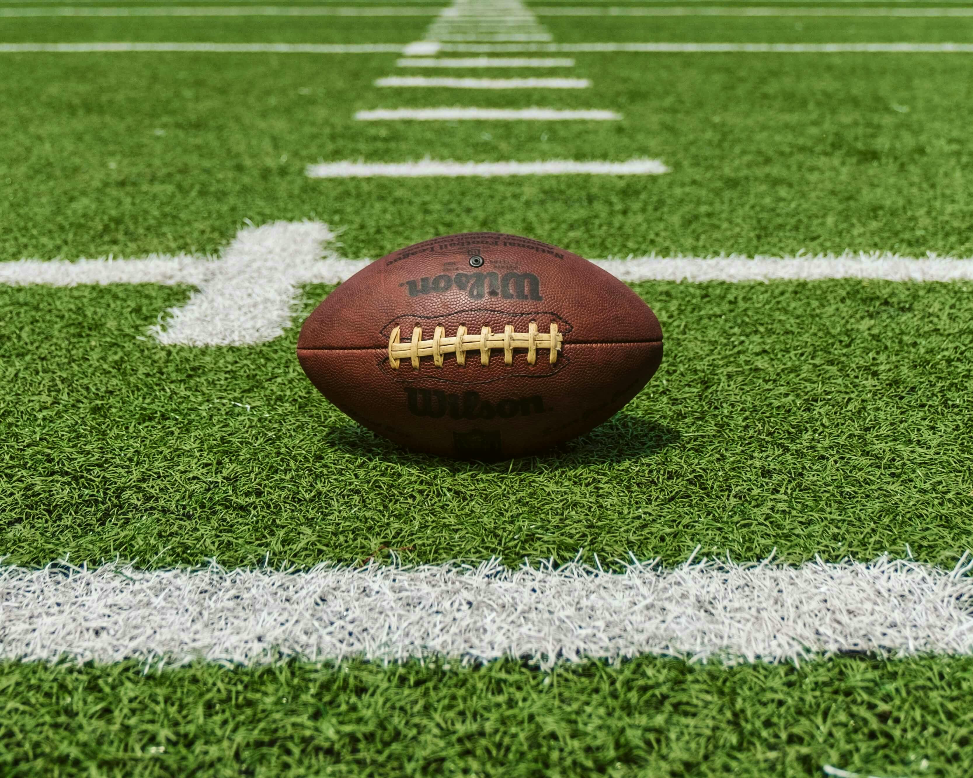 An NFL ball on a football field.